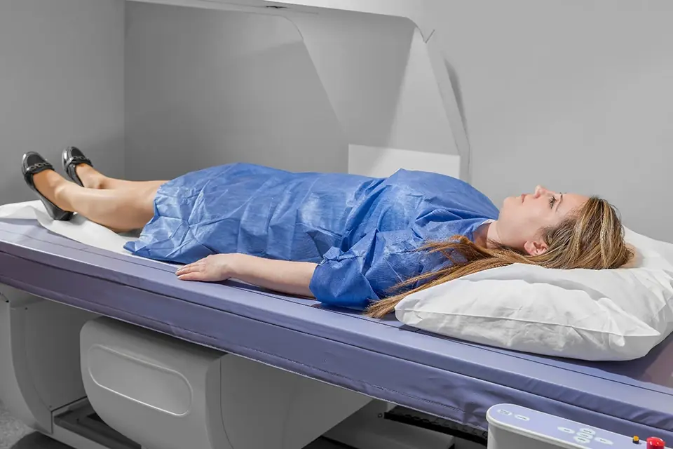 Woman lying on the table of a bone density scanner