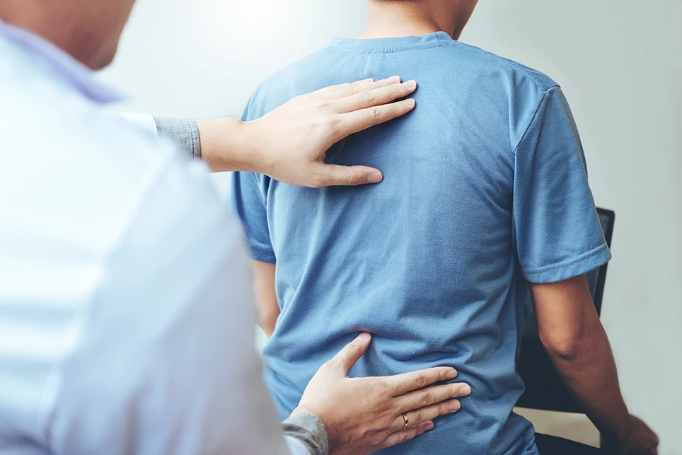 Doctor feeling for patient's back pain